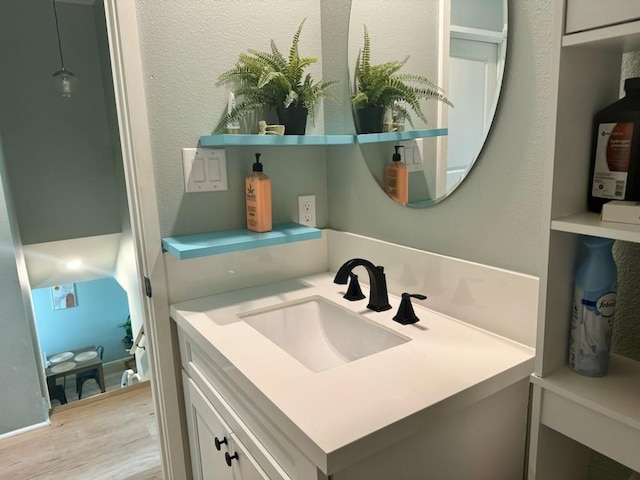 bathroom featuring a textured wall, wood finished floors, and vanity