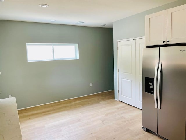 kitchen with light wood-type flooring, visible vents, white cabinetry, and stainless steel refrigerator with ice dispenser