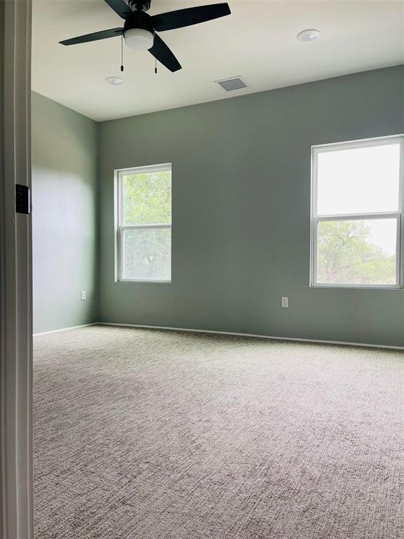 empty room featuring a ceiling fan, baseboards, visible vents, and carpet flooring