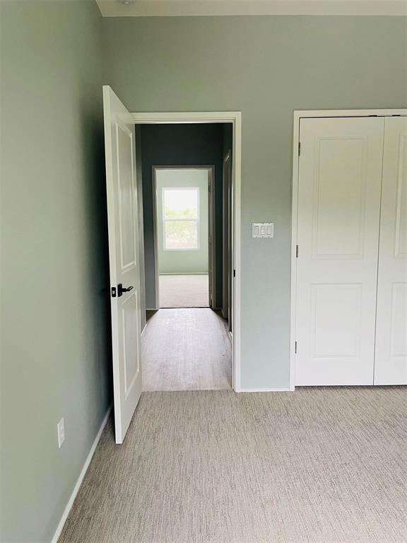 unfurnished bedroom featuring a closet, carpet flooring, and baseboards