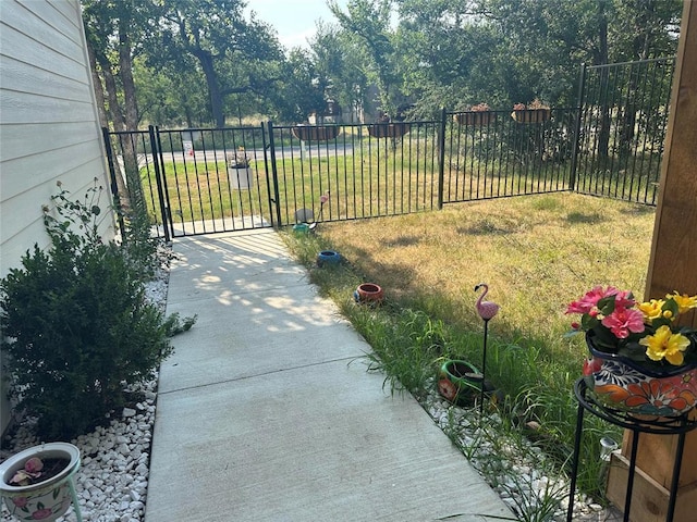 view of gate with fence and a yard