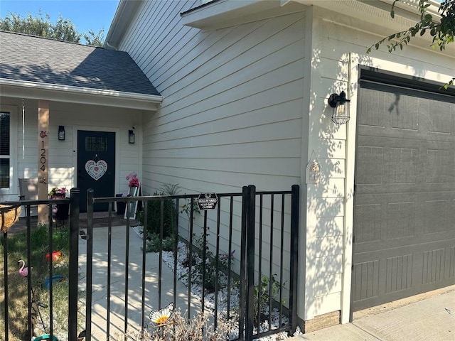 doorway to property with a shingled roof and fence