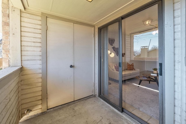 entrance to property featuring brick siding and a balcony