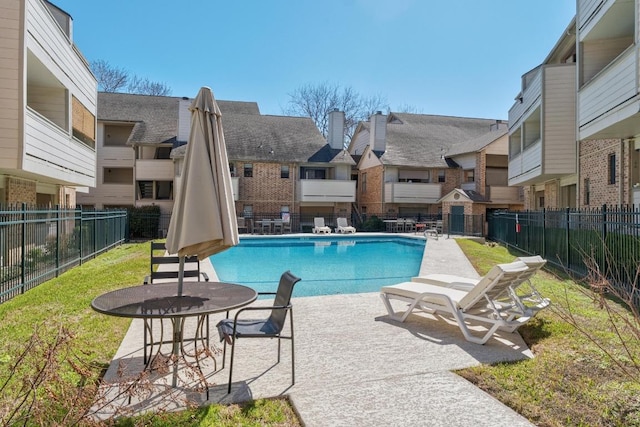 community pool featuring a residential view, a patio area, and fence