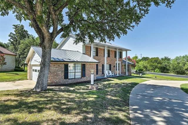 608 Sombrero Dr, Horseshoe Bay, TX 78657 - greek revival house featuring a garage, a front lawn, concrete driveway, and brick siding