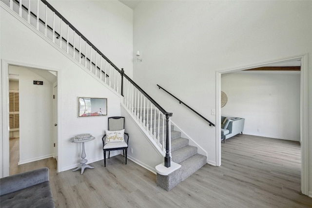 608 Sombrero Dr, Horseshoe Bay, TX 78657 - stairway featuring a towering ceiling, baseboards, and wood finished floors