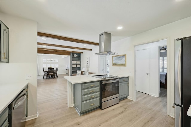 608 Sombrero Dr, Horseshoe Bay, TX 78657 - kitchen with light wood-style flooring, appliances with stainless steel finishes, island exhaust hood, gray cabinets, and light countertops
