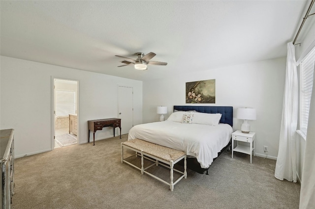 608 Sombrero Dr, Horseshoe Bay, TX 78657 - bedroom with connected bathroom, light colored carpet, ceiling fan, and baseboards