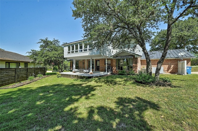 608 Sombrero Dr, Horseshoe Bay, TX 78657 - view of front of house with brick siding, a standing seam roof, fence, a patio area, and a front yard