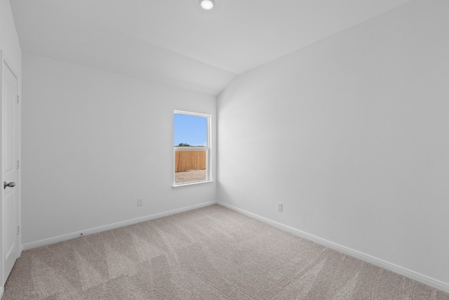 empty room featuring light carpet, vaulted ceiling, recessed lighting, and baseboards