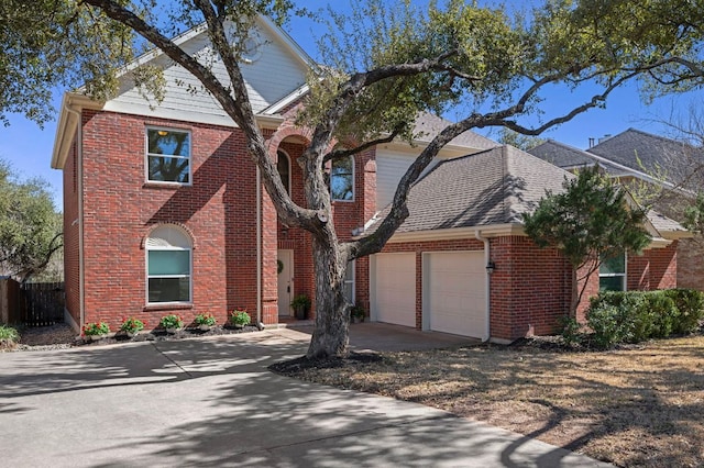 traditional-style house featuring brick siding, a shingled roof, concrete driveway, fence, and a garage