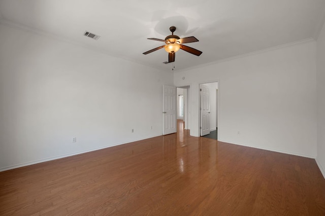 spare room featuring baseboards, visible vents, a ceiling fan, ornamental molding, and wood finished floors