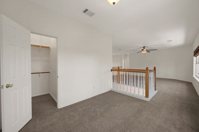 spare room featuring visible vents and dark carpet