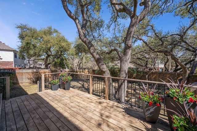 wooden terrace with a fenced backyard