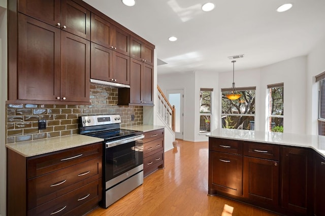 kitchen featuring recessed lighting, hanging light fixtures, light wood-type flooring, decorative backsplash, and stainless steel range with electric stovetop