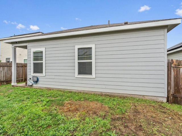 back of house featuring a yard and fence