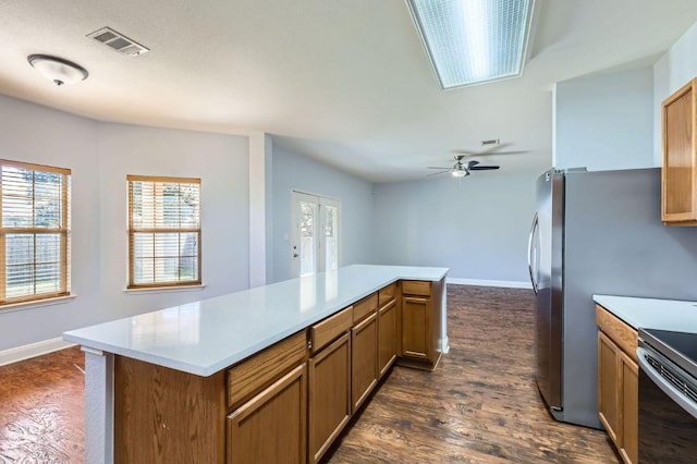 kitchen with light countertops, dark wood finished floors, visible vents, and a kitchen island