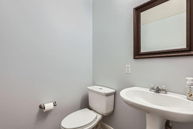 half bath featuring a sink and toilet