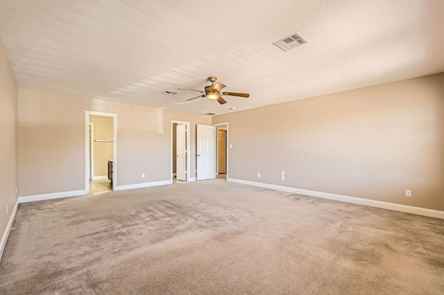 spare room featuring baseboards, visible vents, and light colored carpet