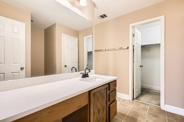 bathroom featuring baseboards, visible vents, tile patterned flooring, and vanity