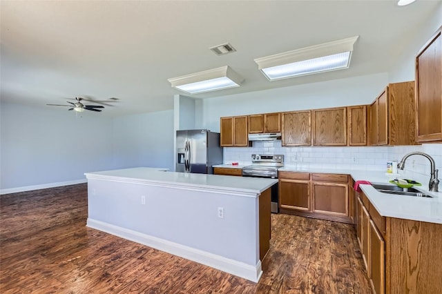 kitchen with visible vents, brown cabinets, stainless steel appliances, under cabinet range hood, and a sink