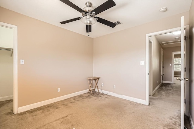 empty room with baseboards, a ceiling fan, visible vents, and light colored carpet