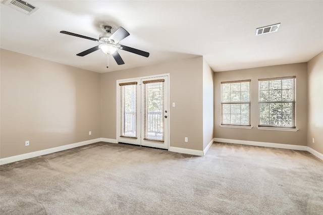 unfurnished room featuring a wealth of natural light, carpet flooring, and visible vents