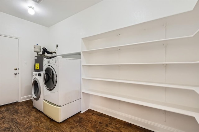 washroom with dark wood-style floors, laundry area, washing machine and clothes dryer, and electric water heater