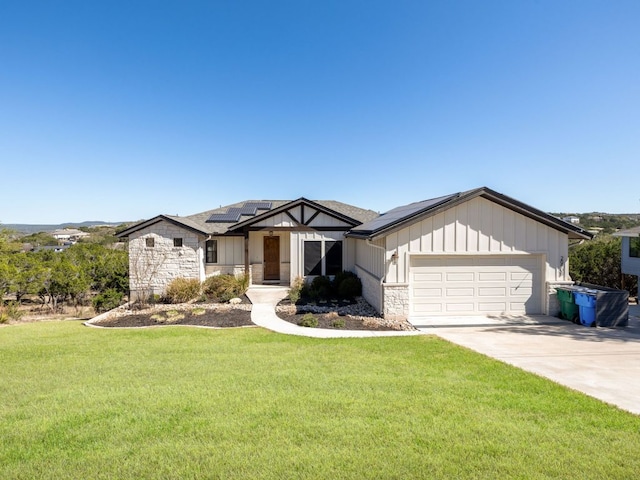 view of front of property featuring solar panels, concrete driveway, stone siding, an attached garage, and a front lawn