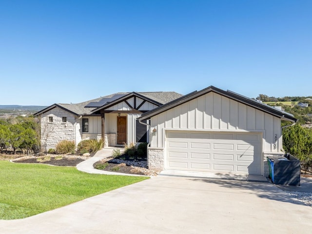 view of front of property featuring an attached garage, stone siding, board and batten siding, and concrete driveway