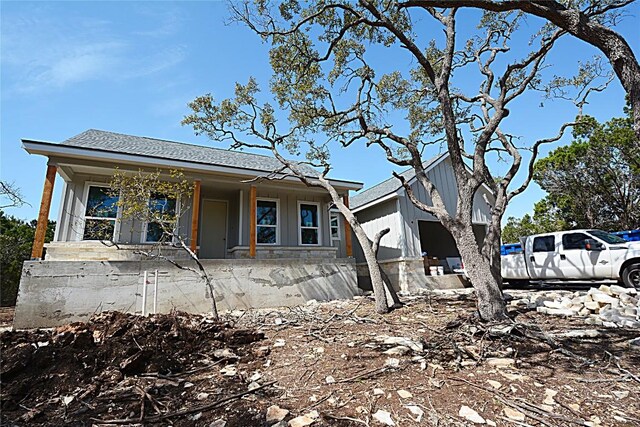 view of front of house with covered porch, a shingled roof, and board and batten siding