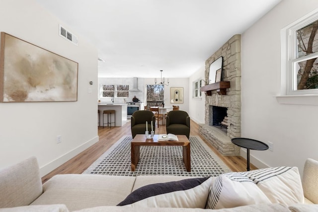 living area featuring plenty of natural light, light wood-type flooring, and visible vents