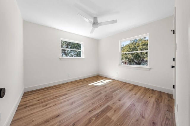 spare room featuring light wood-style flooring, baseboards, and ceiling fan