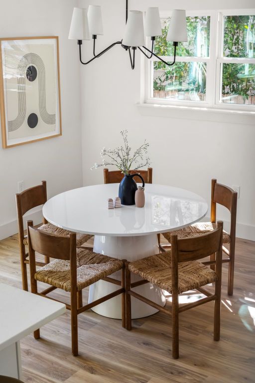 dining space with light wood-style flooring, a chandelier, and baseboards