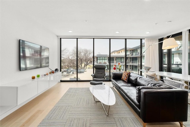 living area with recessed lighting, light wood-type flooring, and floor to ceiling windows