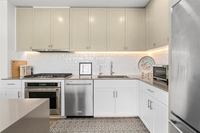 kitchen with appliances with stainless steel finishes, range hood, a sink, and backsplash