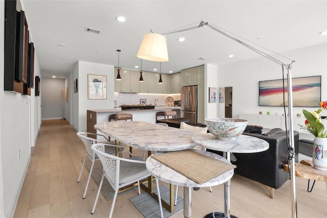 dining area featuring baseboards, light wood-type flooring, visible vents, and recessed lighting