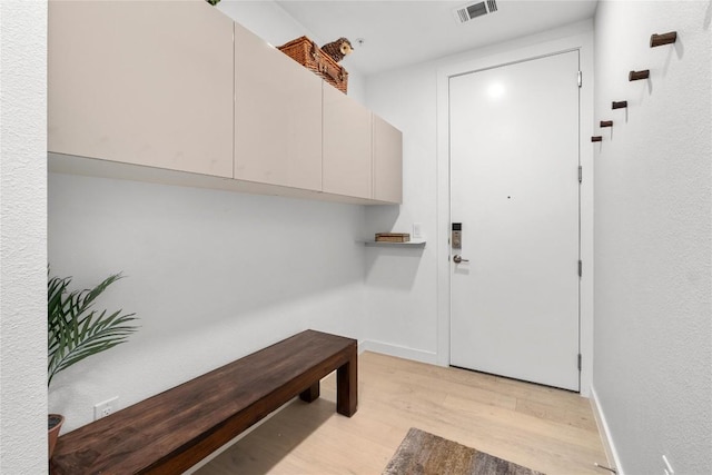 foyer entrance featuring light wood-type flooring, baseboards, and visible vents