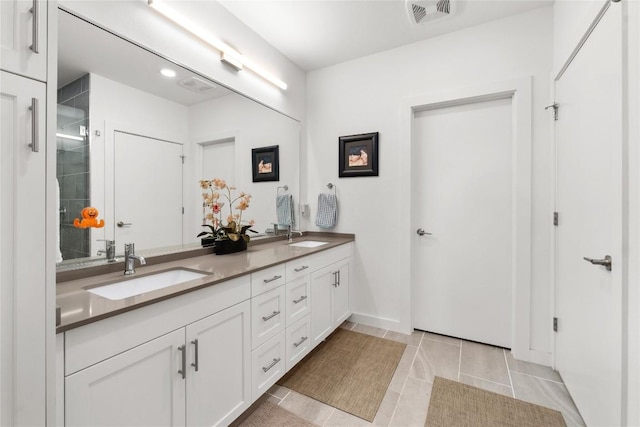 bathroom with a stall shower, visible vents, a sink, and double vanity