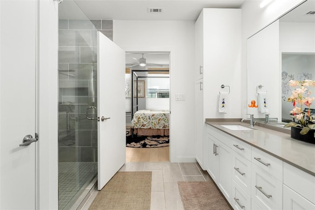 ensuite bathroom with connected bathroom, vanity, visible vents, a ceiling fan, and a stall shower