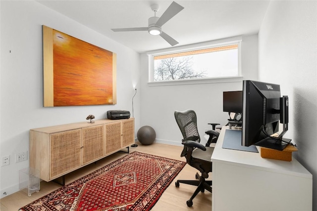 office space featuring ceiling fan and baseboards