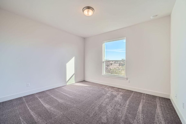 empty room featuring carpet flooring and baseboards