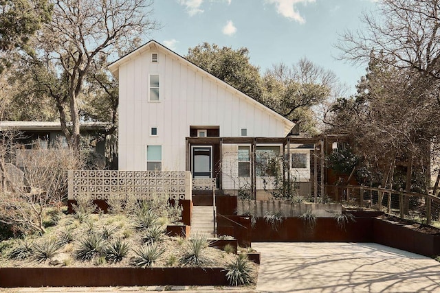 view of front of home with board and batten siding and fence