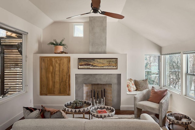 living room featuring vaulted ceiling, a fireplace, baseboards, and ceiling fan