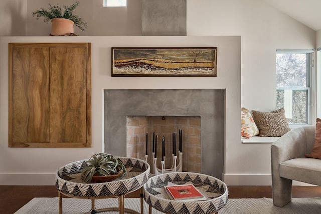 sitting room with lofted ceiling, a fireplace, and baseboards