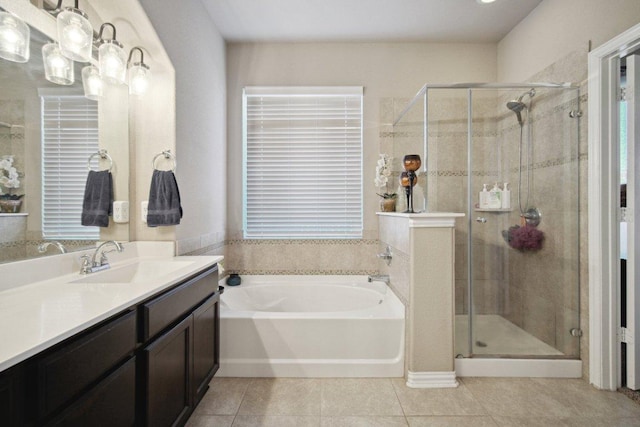 bathroom featuring a stall shower, tile patterned flooring, a garden tub, and vanity