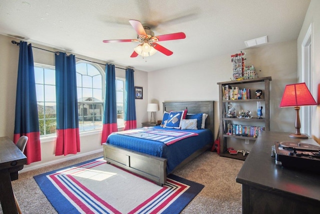 bedroom featuring carpet floors, multiple windows, visible vents, and a ceiling fan