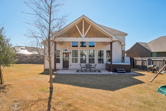 rear view of house featuring a lawn, a patio area, a fenced backyard, and a hot tub