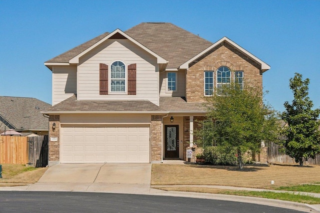 view of front facade with a garage, brick siding, fence, driveway, and a front lawn