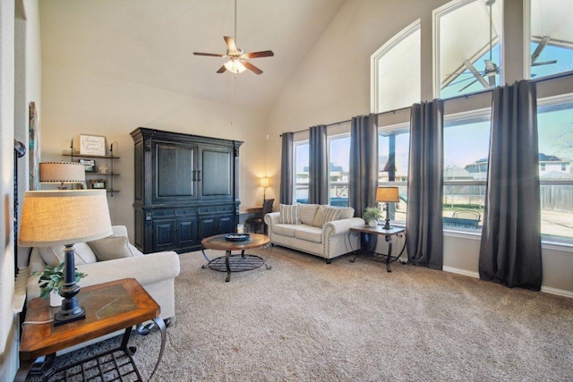 living room with high vaulted ceiling, carpet, baseboards, and a ceiling fan